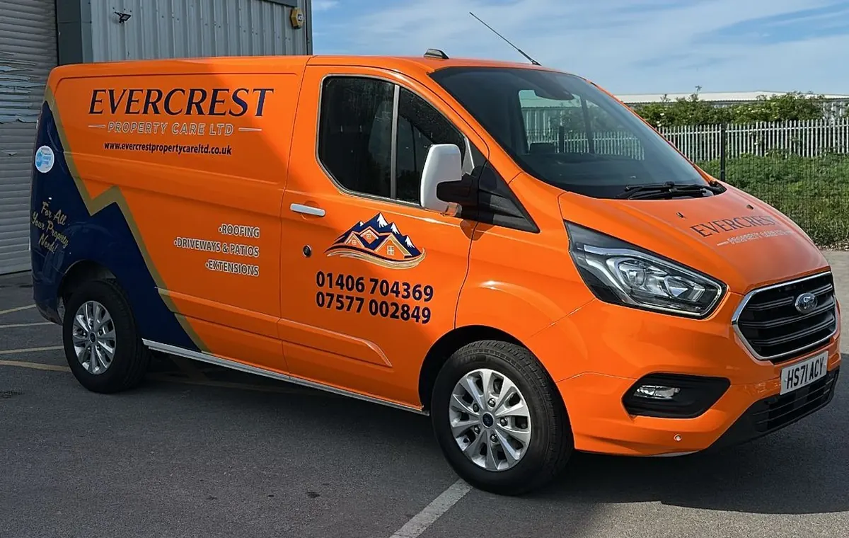 Evercrest Property Care Ltd branded orange service van showing roofing, driveways & extensions services and phone numbers